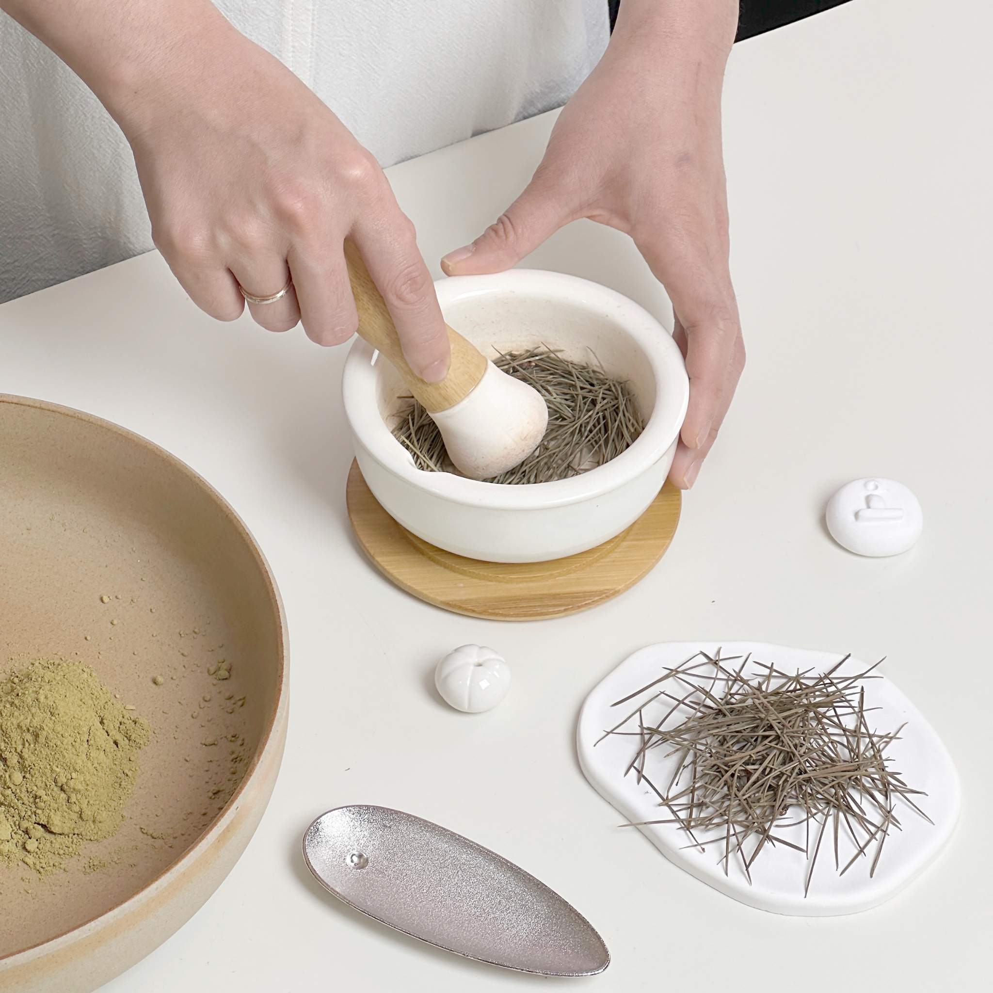 Craftsman hand-grinding cedar powder to highlight traditional craftsmanship and natural ingredients